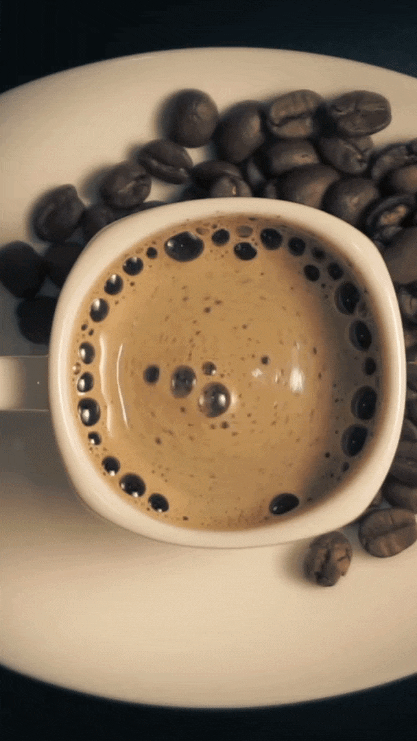 Cinematic overhead view of coffee with latte art swirl, loop animation