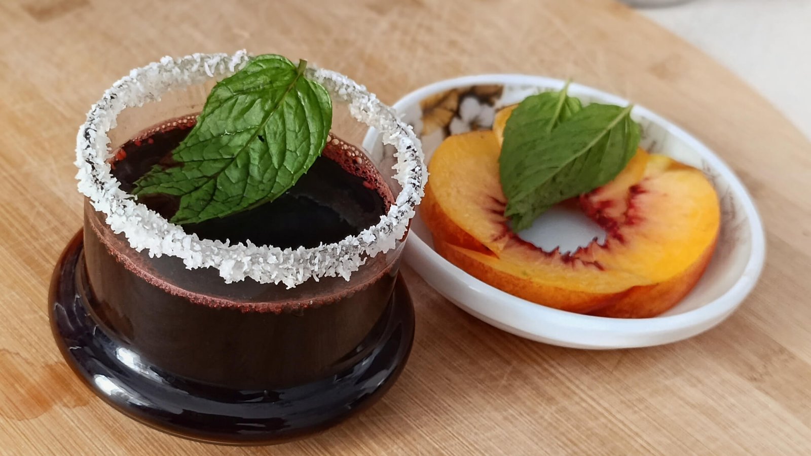 Close-up of Red Blush Mint Turkish Coffee with a coconut rim and fresh mint leaf garnish.
